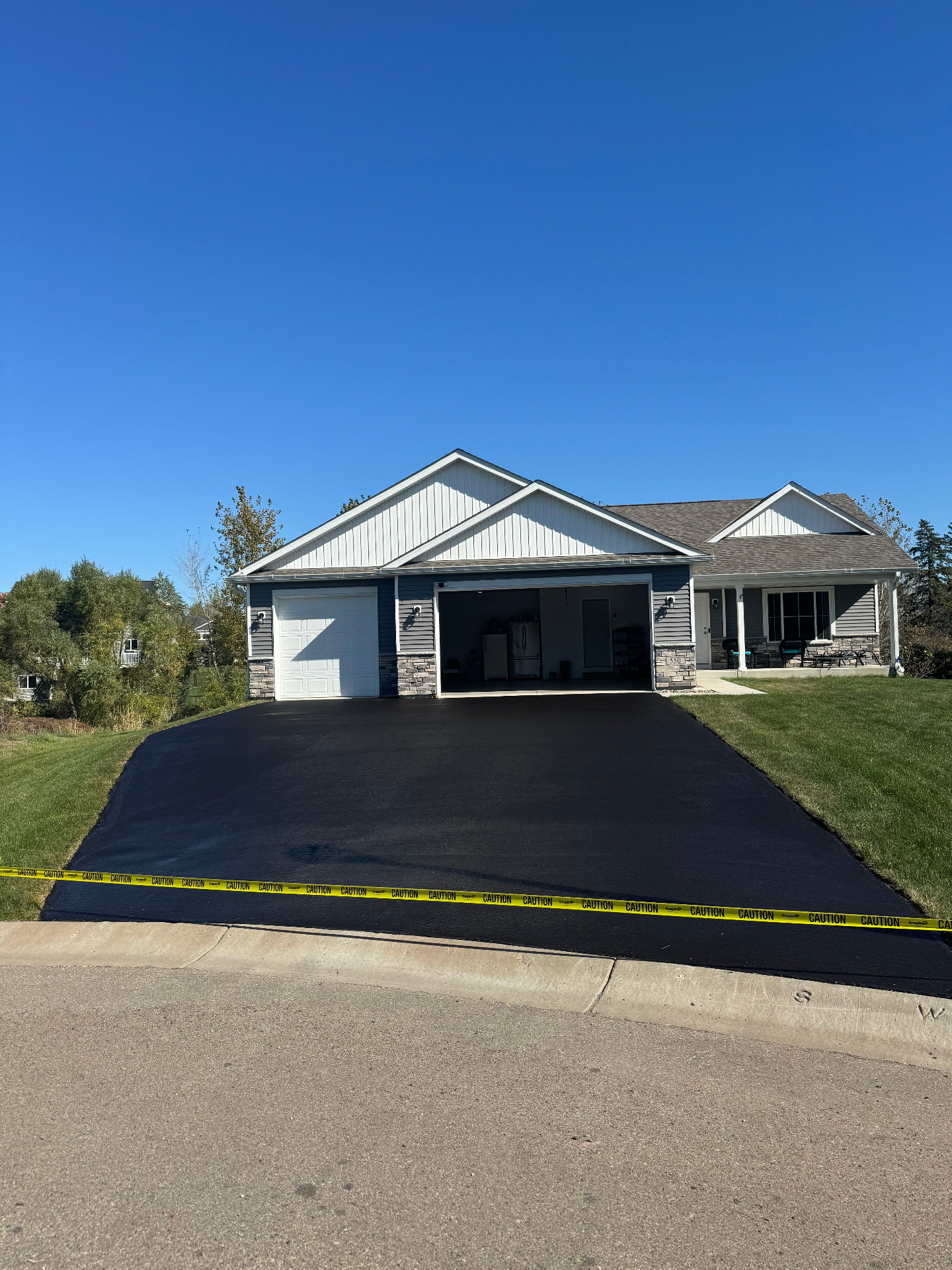 Same driveway after professional seal coating with a deep black finish