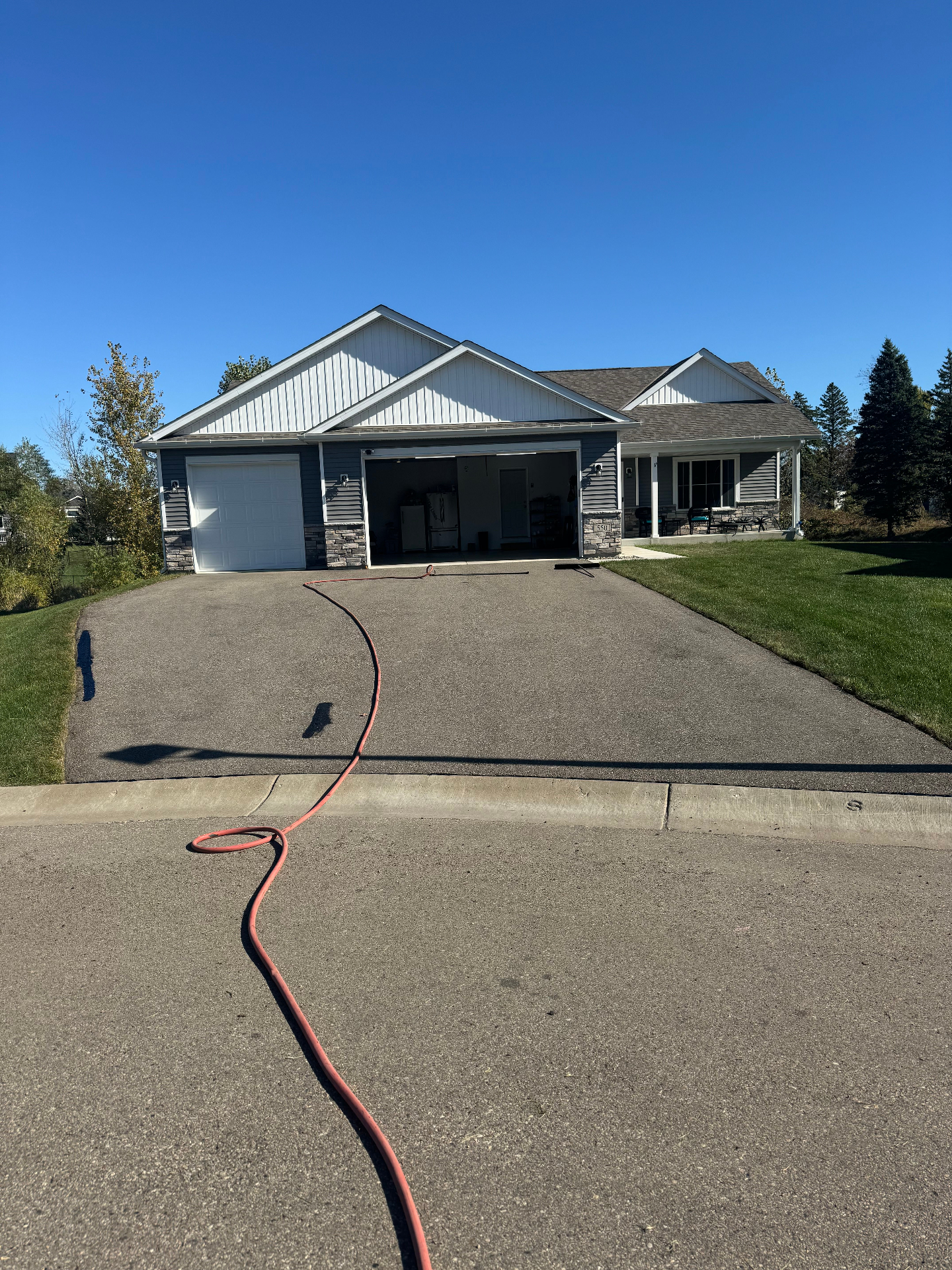 Faded gray asphalt driveway before seal coating treatment