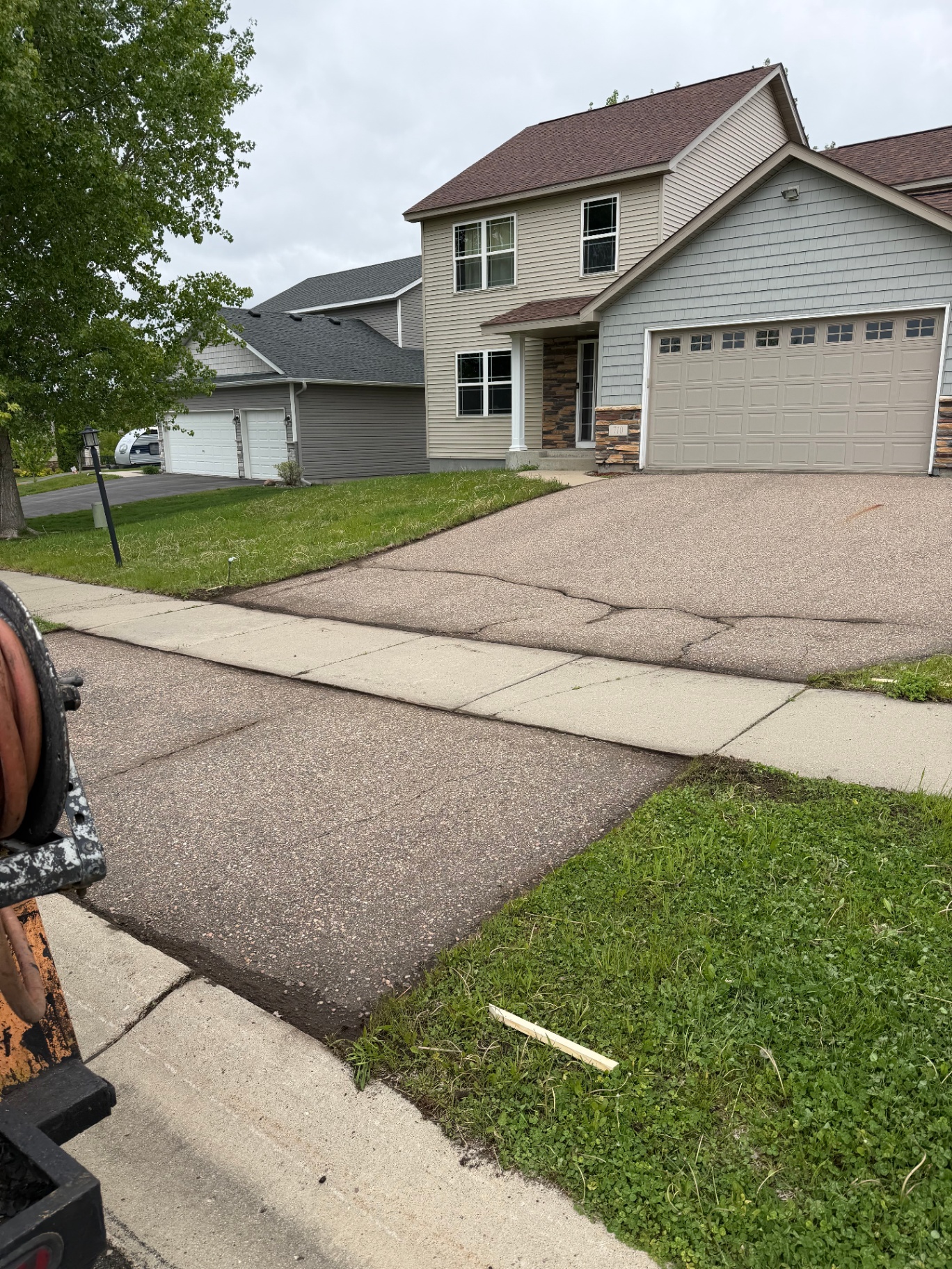 Residential driveway before resurfacing or seal coating with a faded aggregate-toned surface